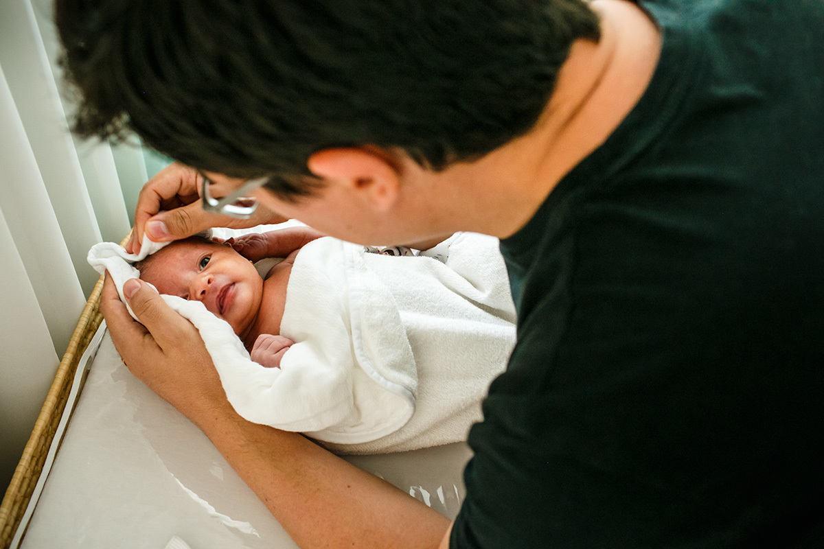 pai enxuga sua bebê recém-nascida após o banho