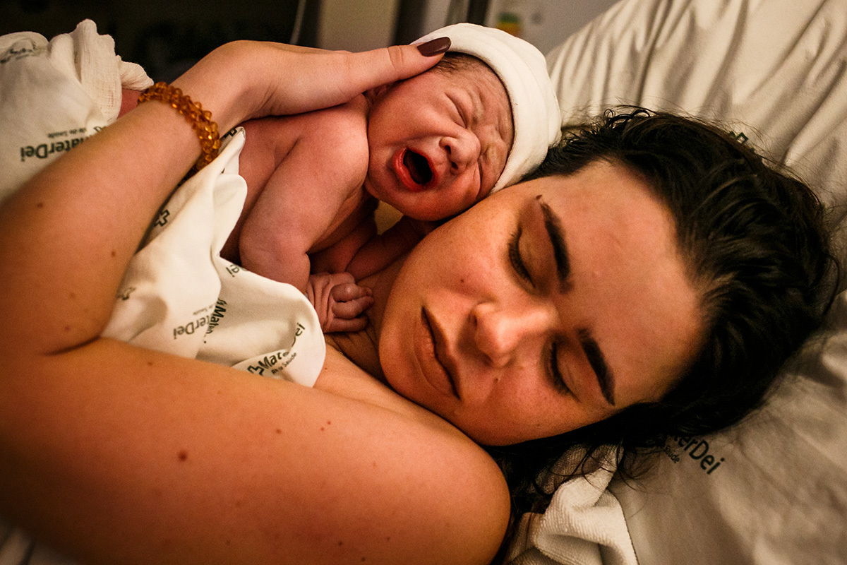 mãe abraça emocionada seu filho que acabou de nascer