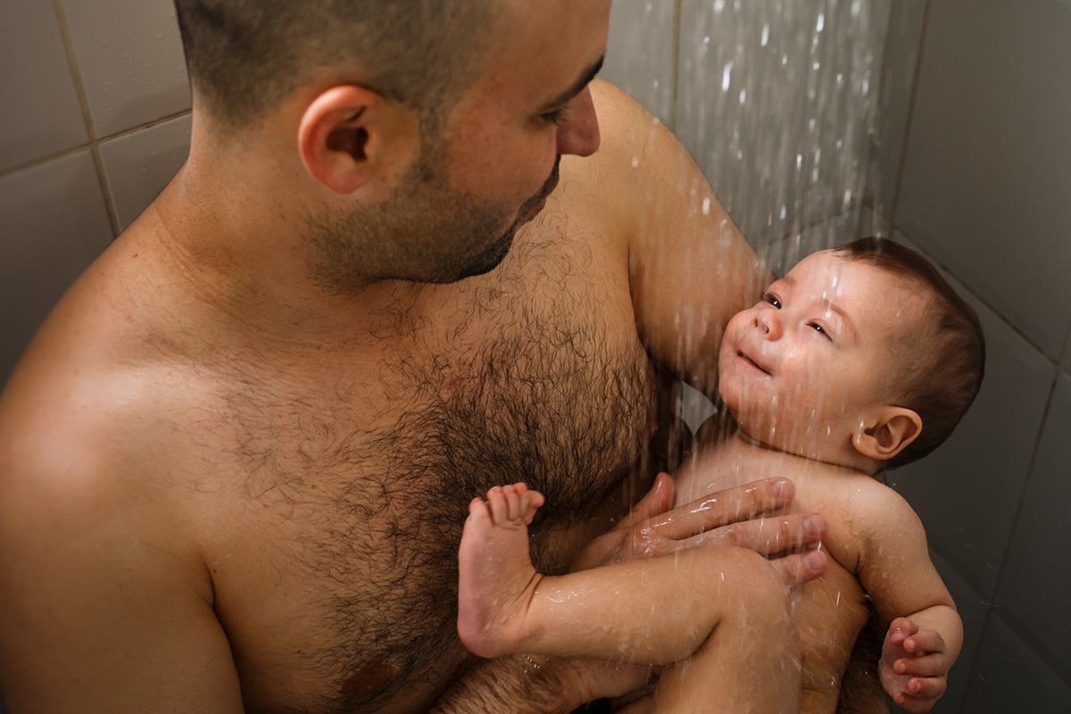 pai dando banho no seu bebê de 6 meses no chuveiro