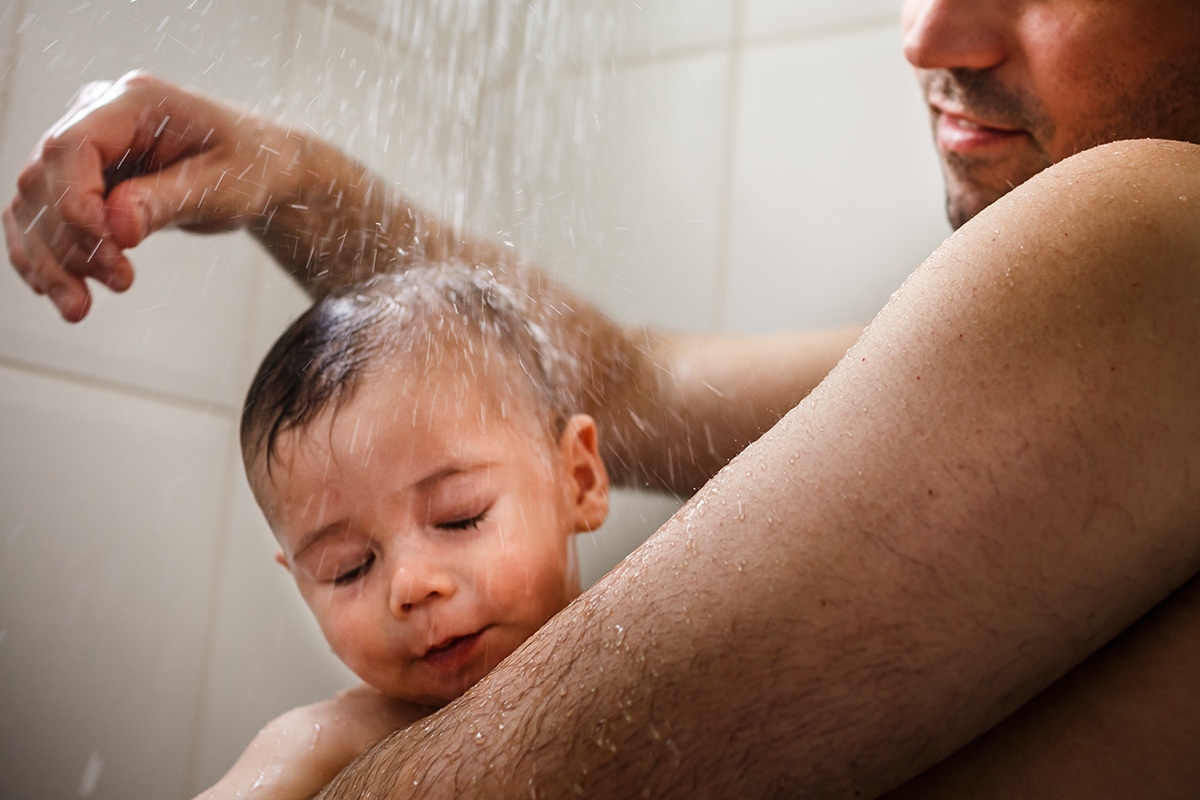 pai e filho tomando banho de chuveiro