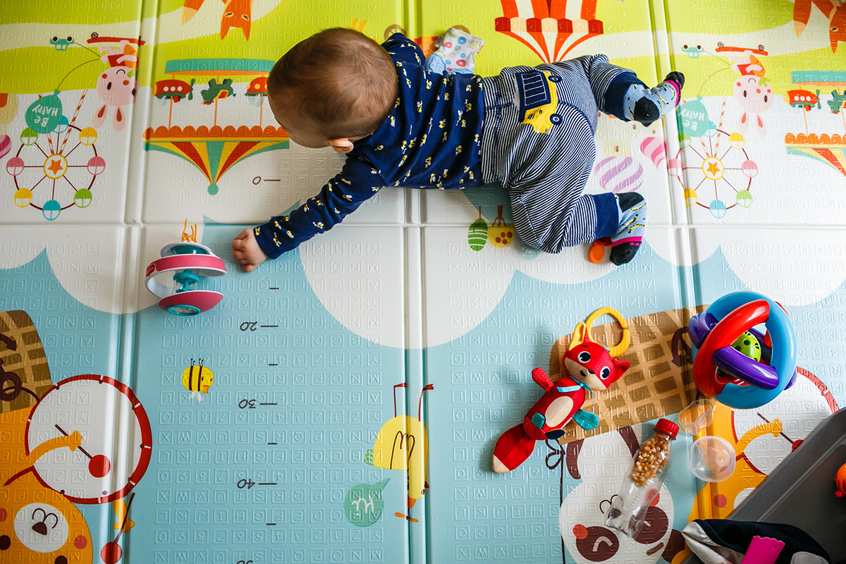 bebê de 6 meses brincando no tapete para aprender a engatinhar