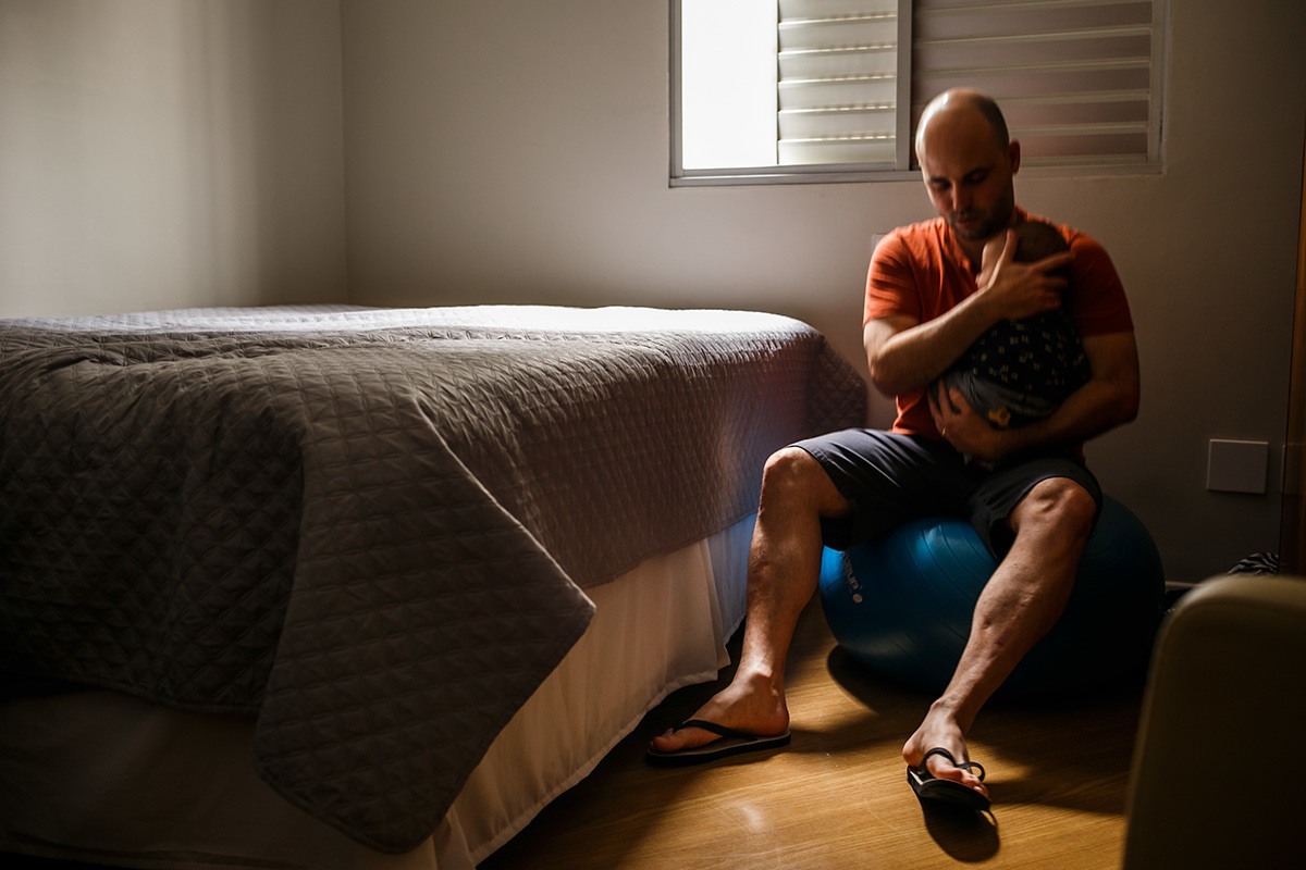 pai fazendo seu bebê dormir com o balanço na bola de pilates