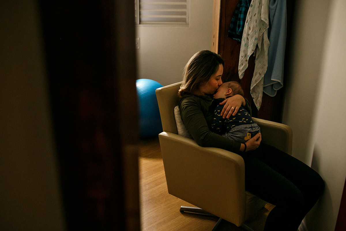 mãe com seu bebê dormindo no colo em foto de Adriana Costa