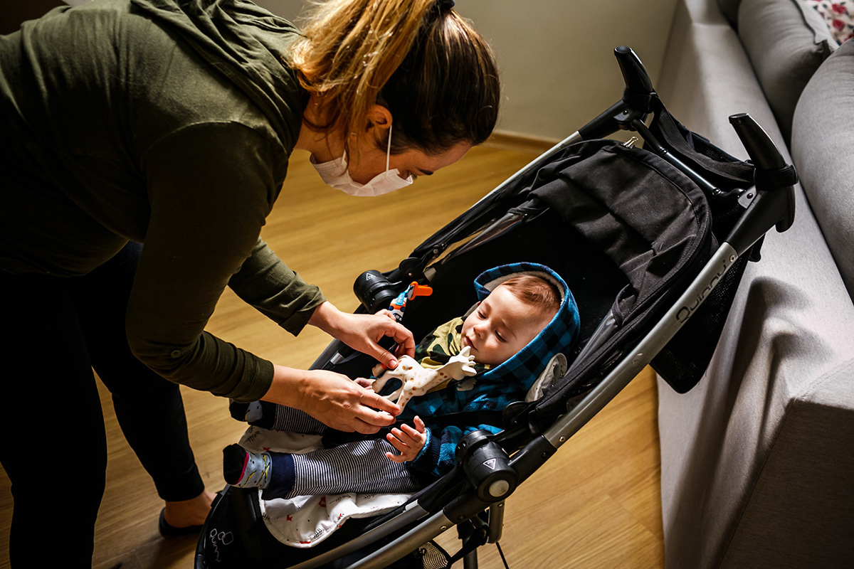 mãe preparando seu bebê para passear