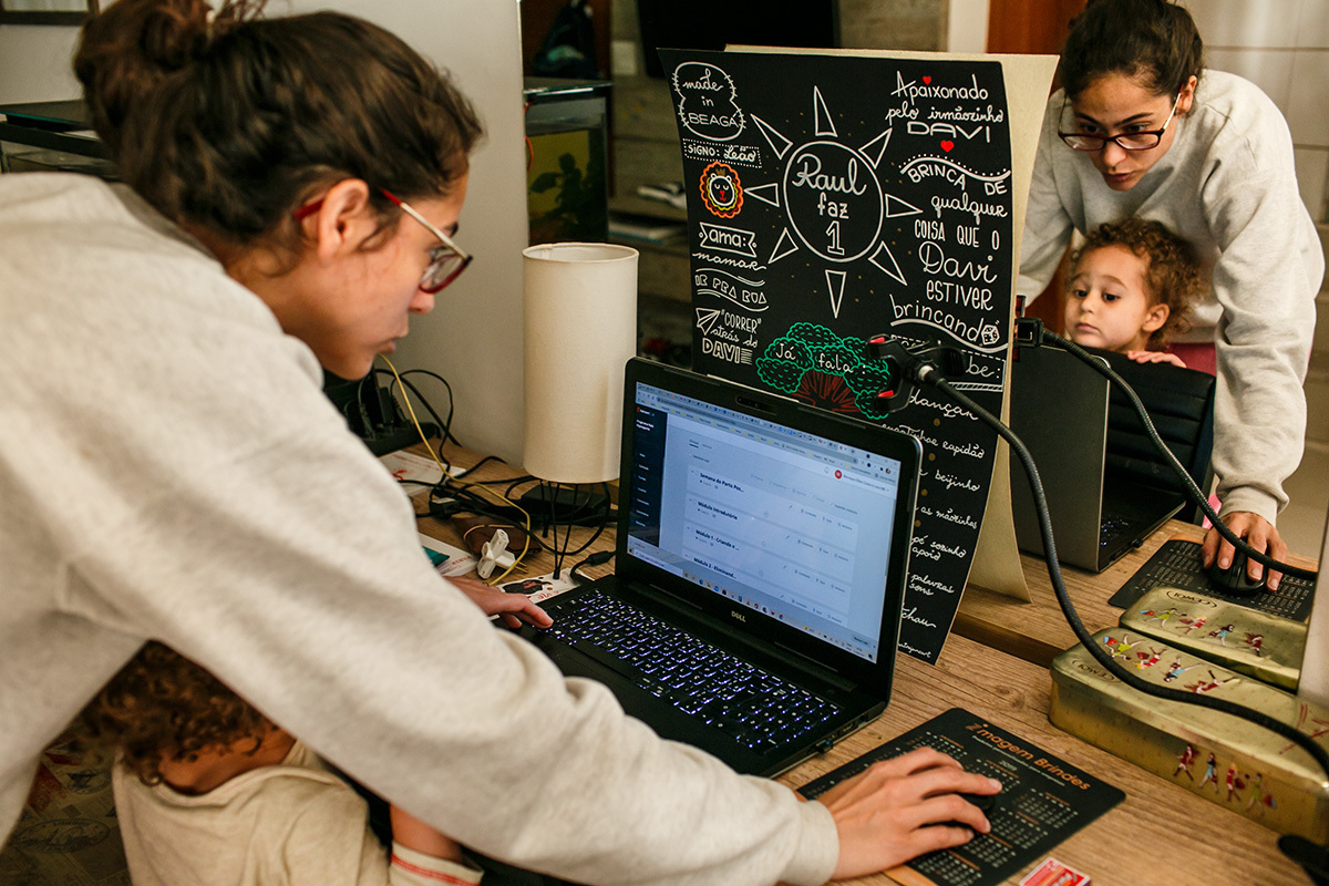 criança observa mãe trabalhar junto a um lettering lindo do 1 ano do caçula