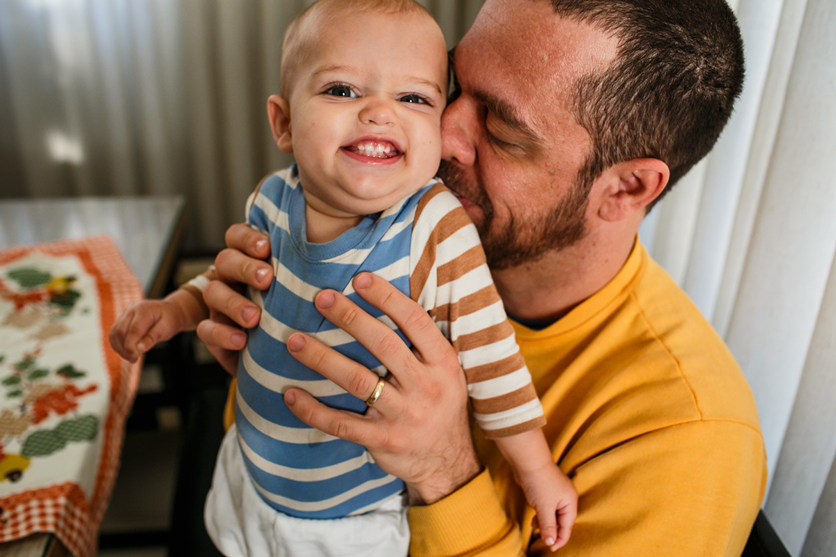 bebê sorri com o cheiro de pai em foto de Adriana Costa