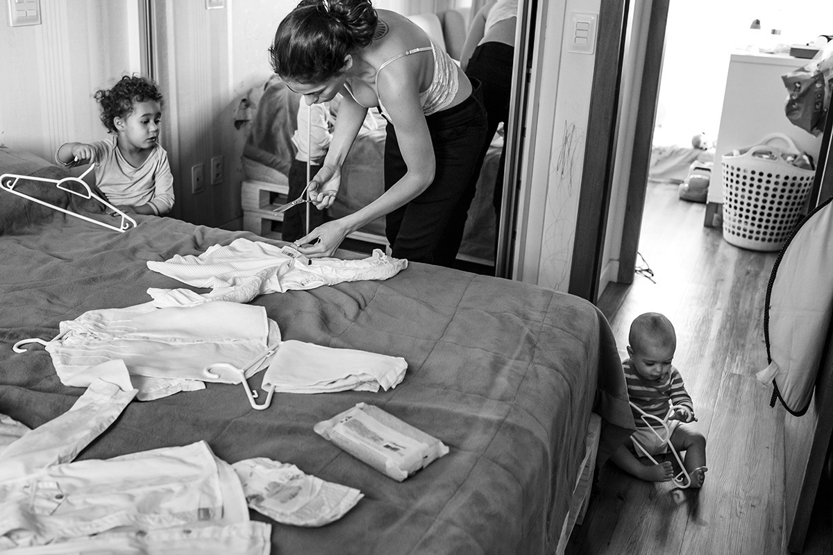 foto de Adriana costa da mãe preparando as roupas do batizado para as crianças
