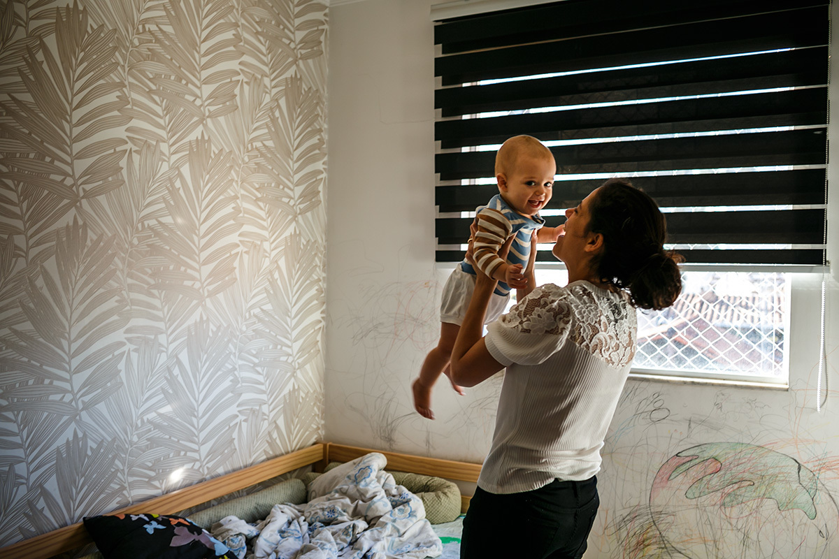 mãe brinca com seu bebê no dia do batizado
