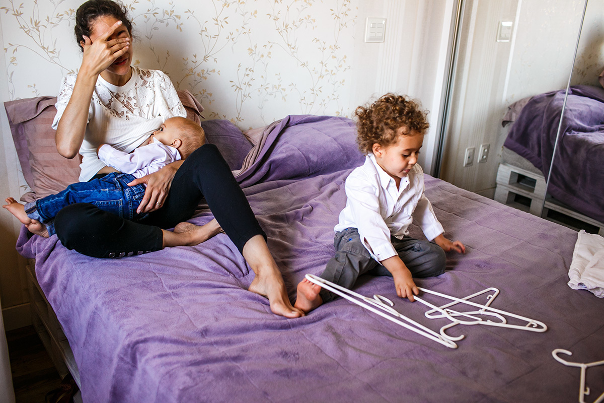 mãe amamenta antes de ir para o batizado do filho