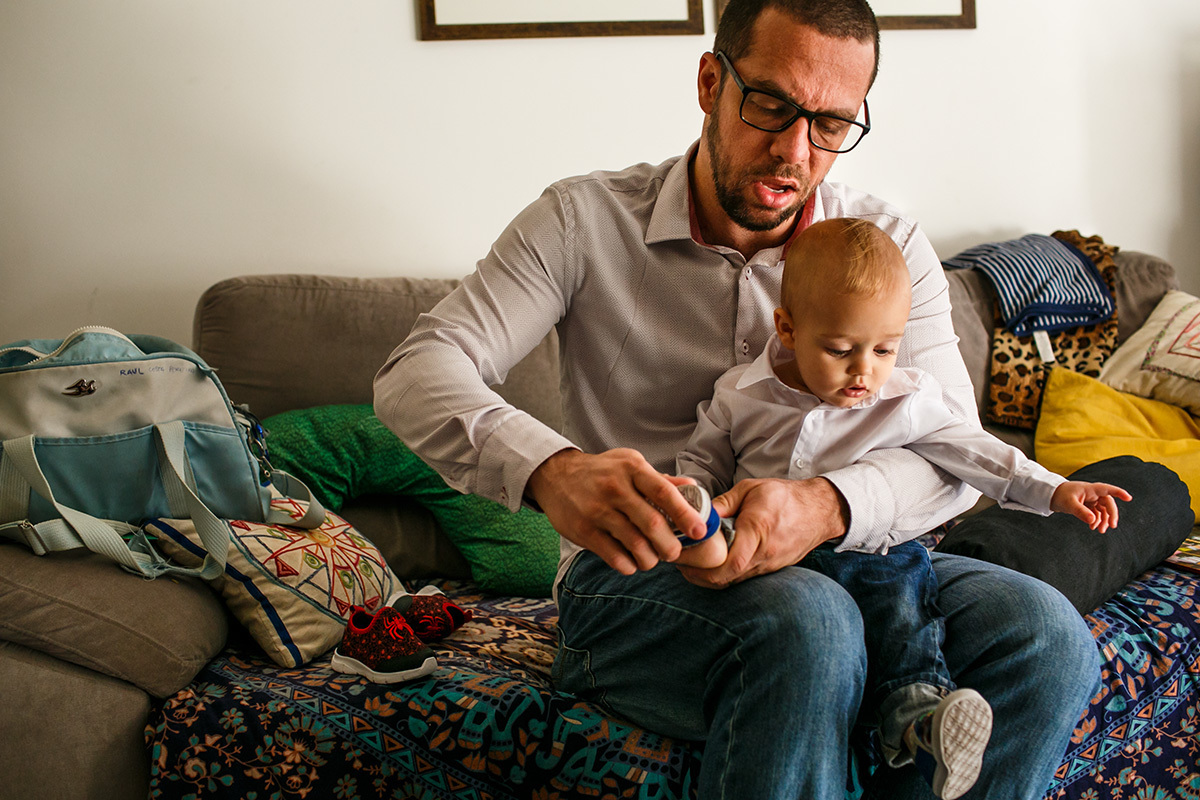 bebê observa seu pai colocando sapatos nele