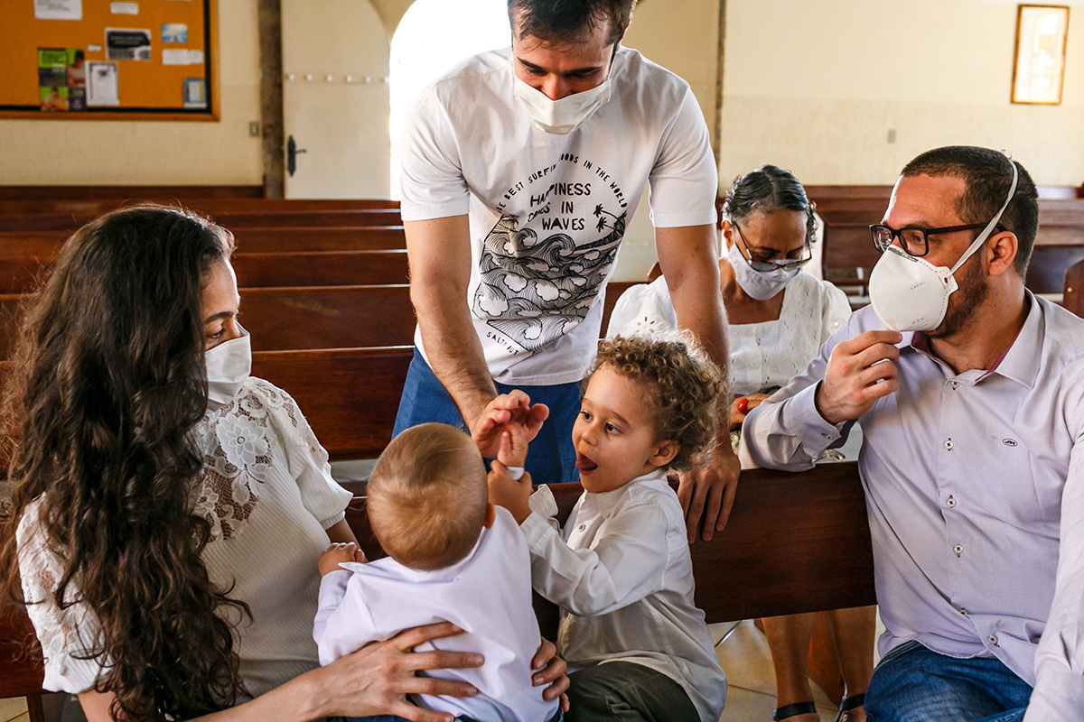 bebê cumprimentando seu padrinho que chegou para o batizado