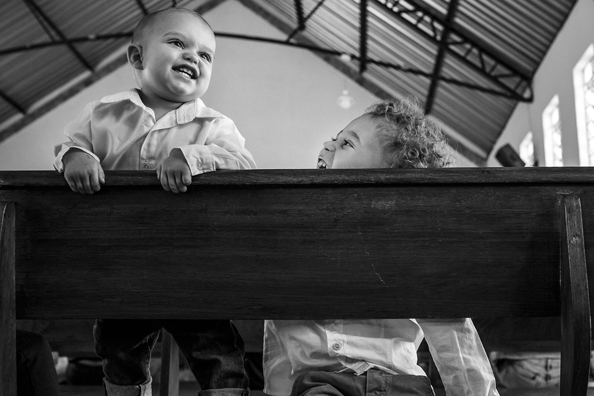 irmãos se divertem durante o batizado