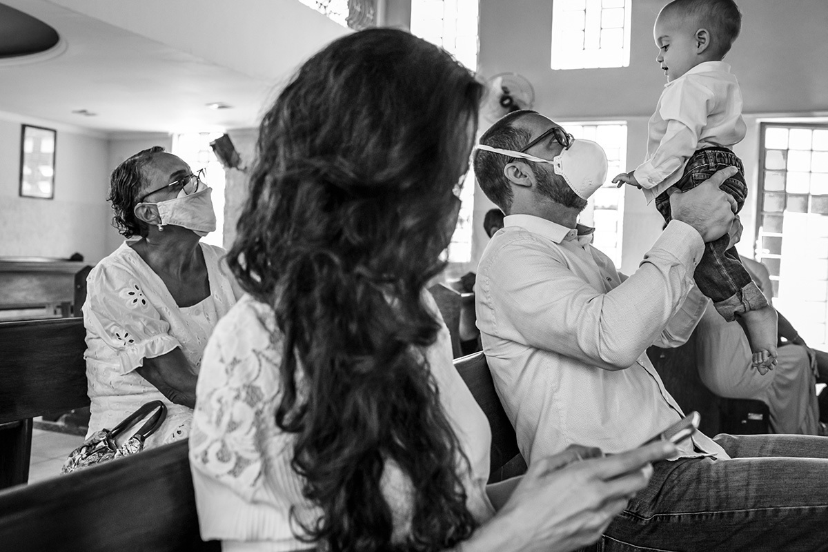 pai brinca com seu bebê durante o batizado