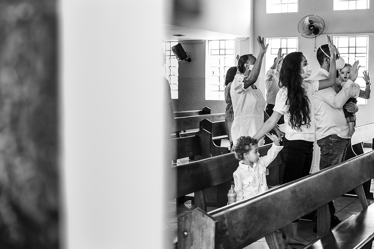 crianças acompanhando os adultos na reza durante o batizado