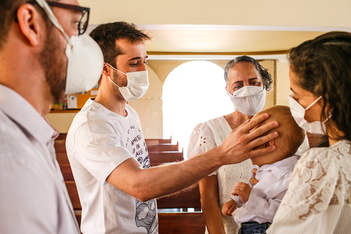 padrinho abençoa seu afilhado na missa de batismo