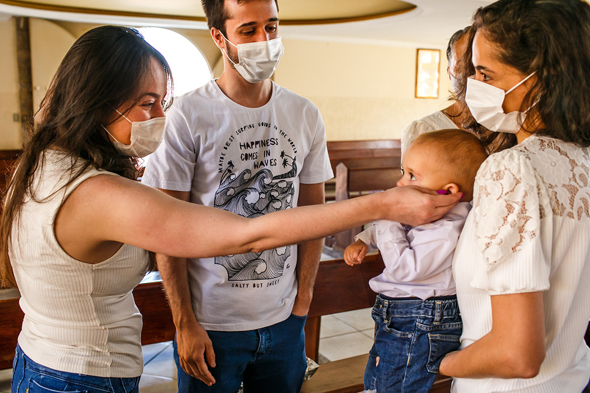 madrinha abençoa seu afilhado na missa de batismo