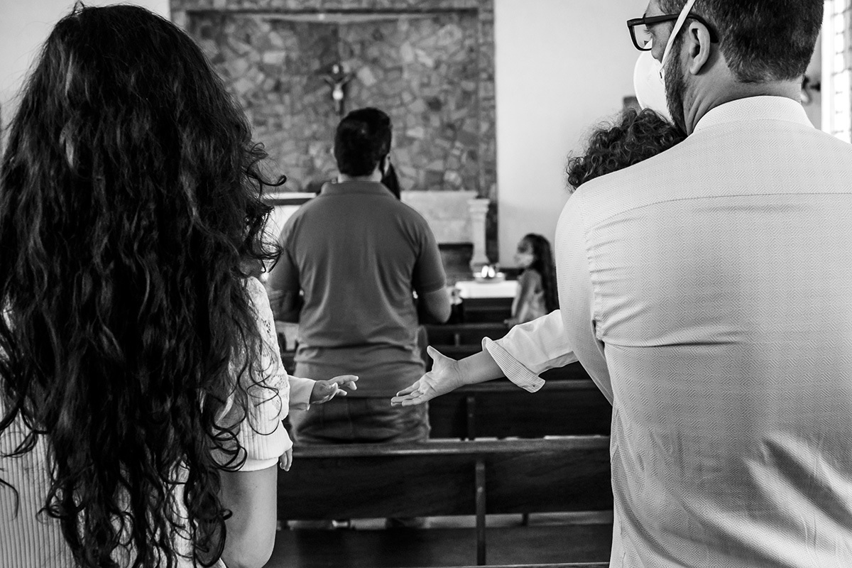 irmãos querem dar as mãos durante a missa de batismo
