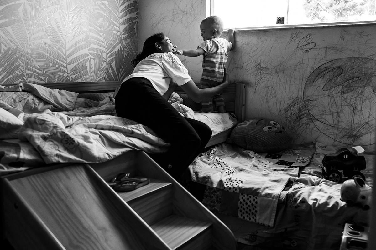 mãe e bebê brincando no quarto após o batizado em foto de Adriana Costa