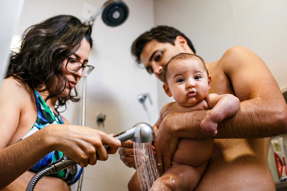 casal e sua bebê no banho de chuveiro