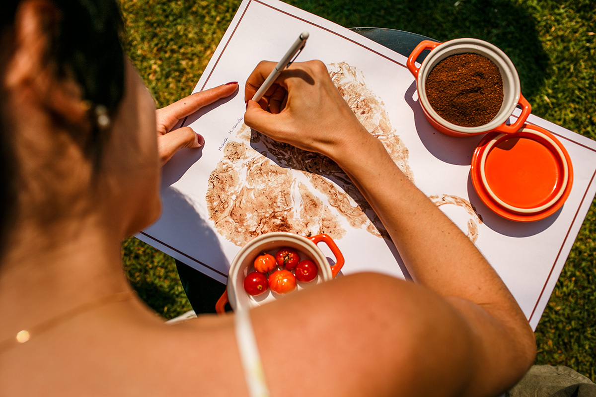 madrinha escreve no carimbo da placenta da sua afilhada enquanto os pais enterram a placenta como símbolo de batismo da filha