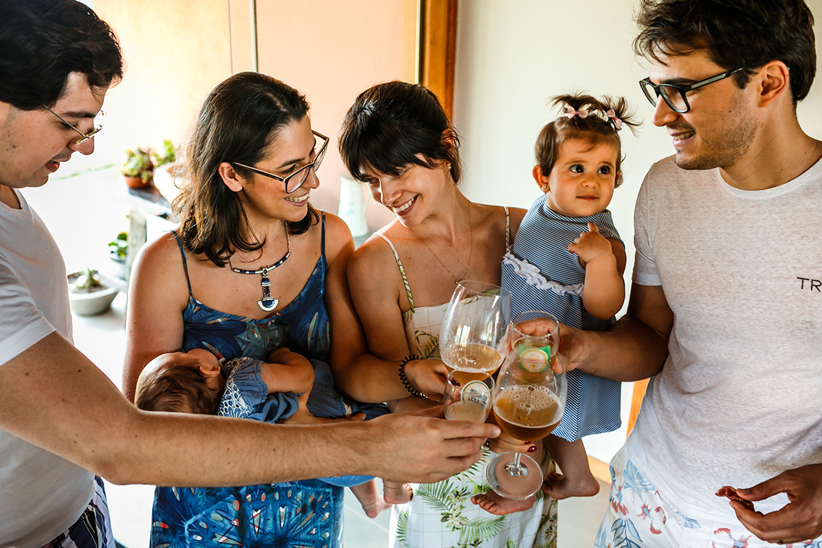 pais e padrinhos brindam ao batismo da filha