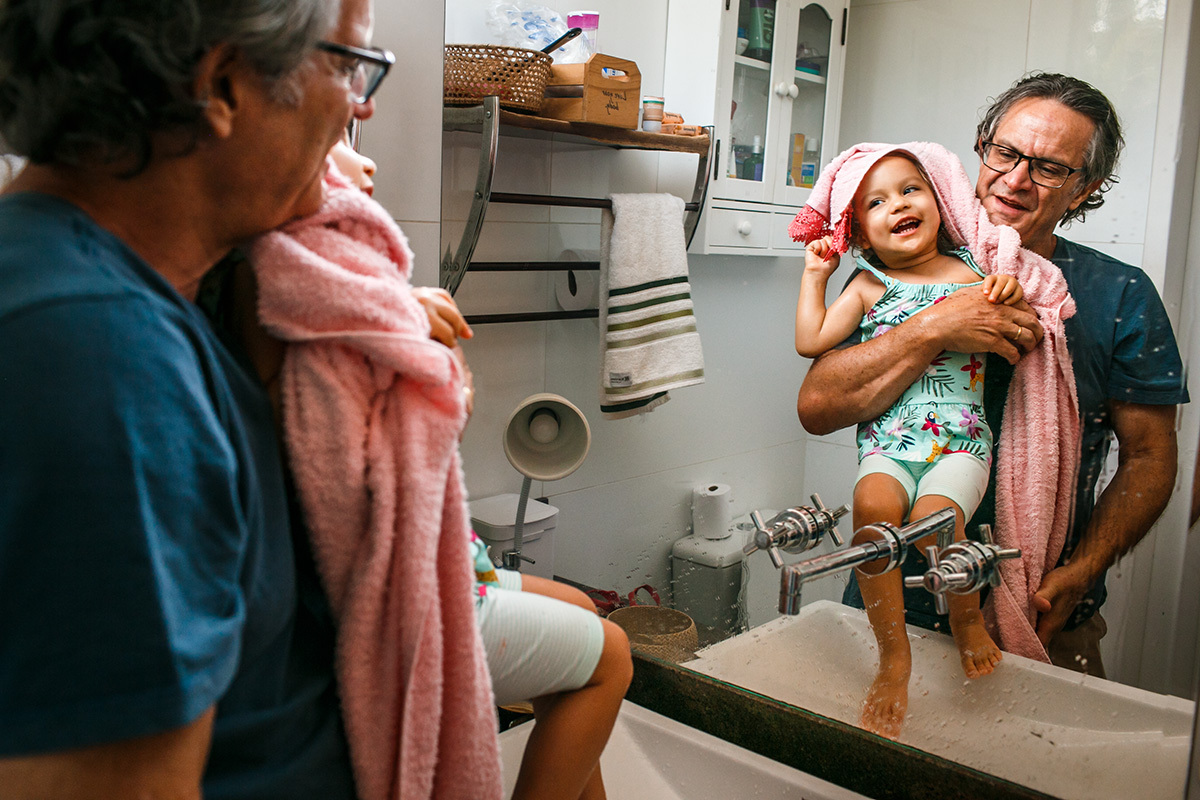 pai limpando sua filha que estava suja do bolo de aniversário