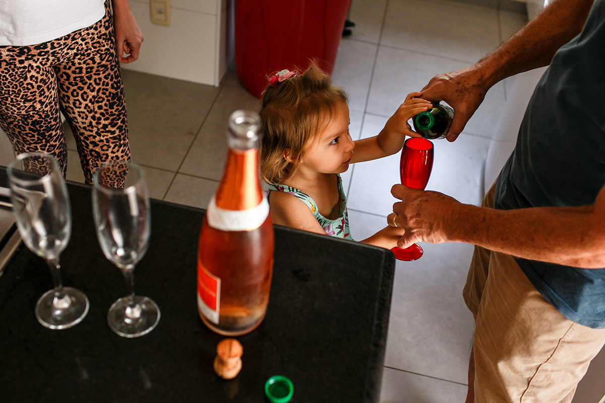 pai coloca refrigerante na taça de sua filha para brindar com eles a boda de madeira de seu casamento