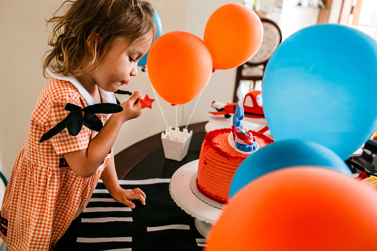 menina fura o seu bolo antes do parabéns