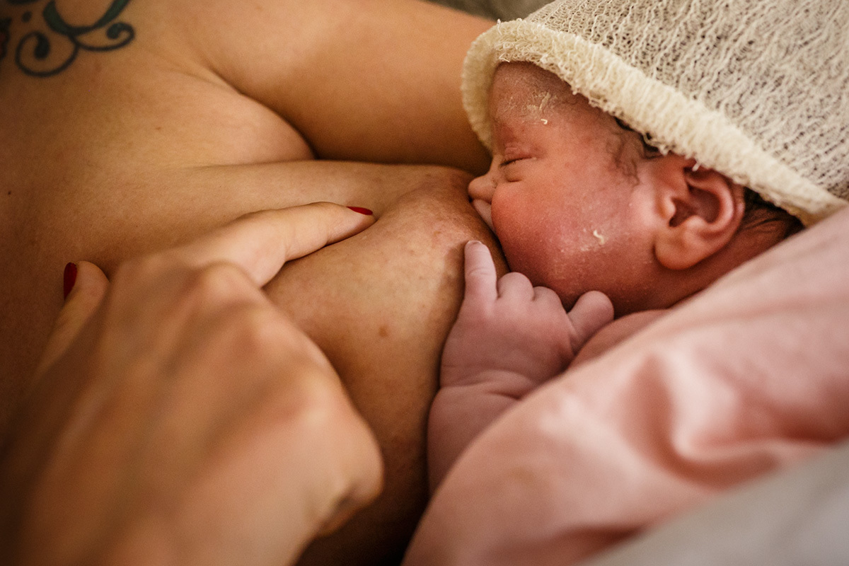 Foto de Adriana Costa da bebê amamentando após cesárea