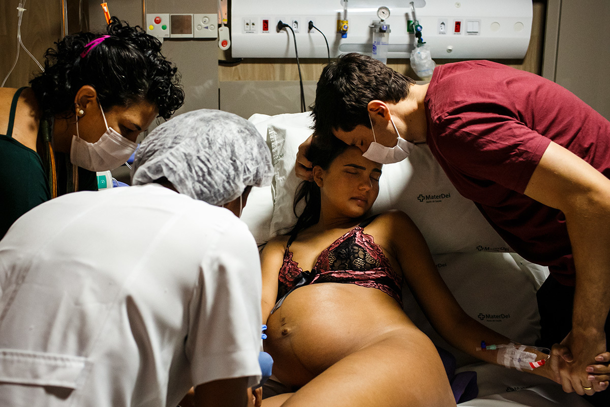 marido apoia a mulher enquanto ela recebe medicação durante o trabalho de parto