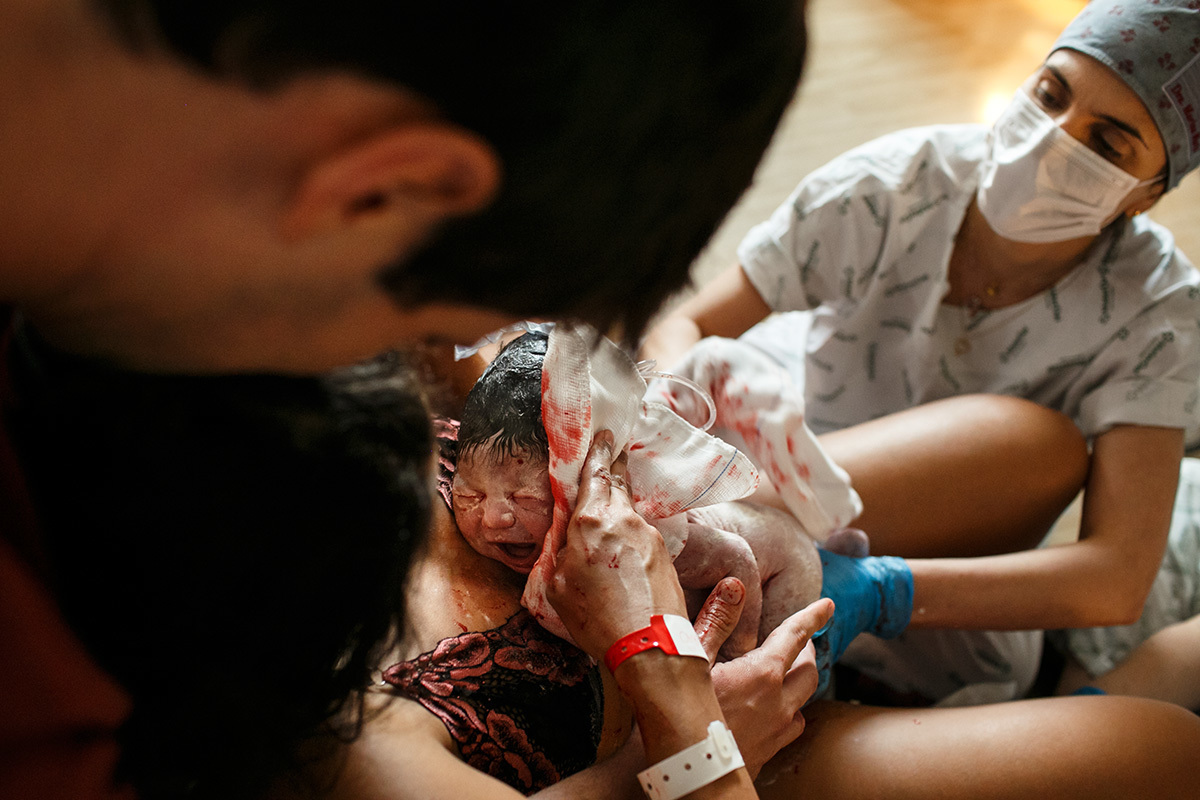 mãe recebe seu bebê que acabou de nascer de parto normal nos braços