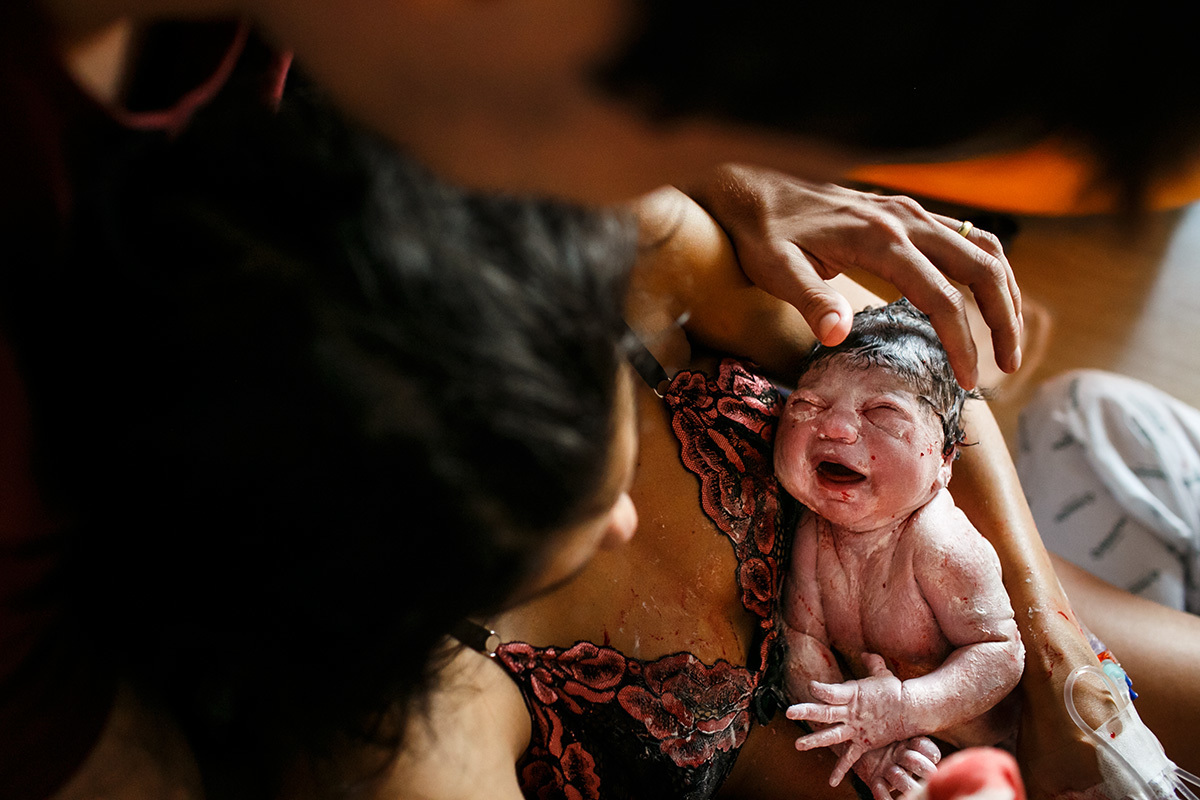 casal admira seu bebê que acabou de nascer de parto normal com assistência da Casa Perinatal de BH