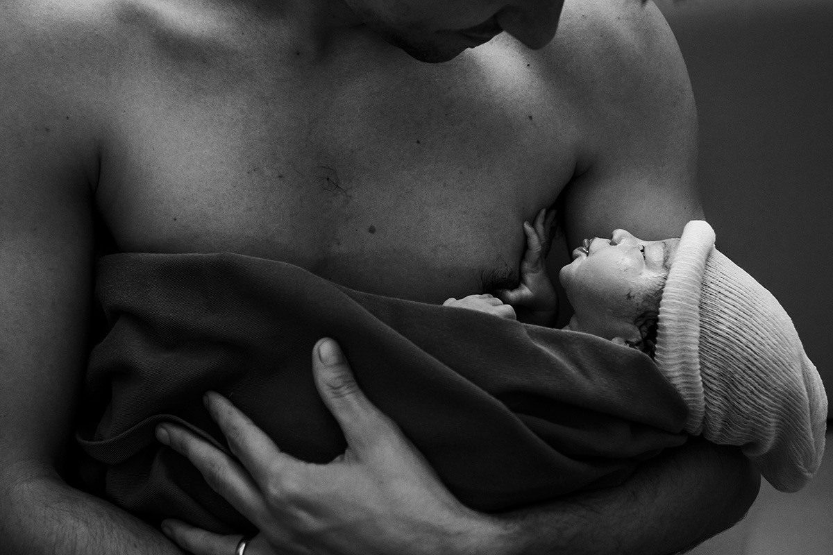 bebê faz careta de língua para o seu pai logo após o nascimento