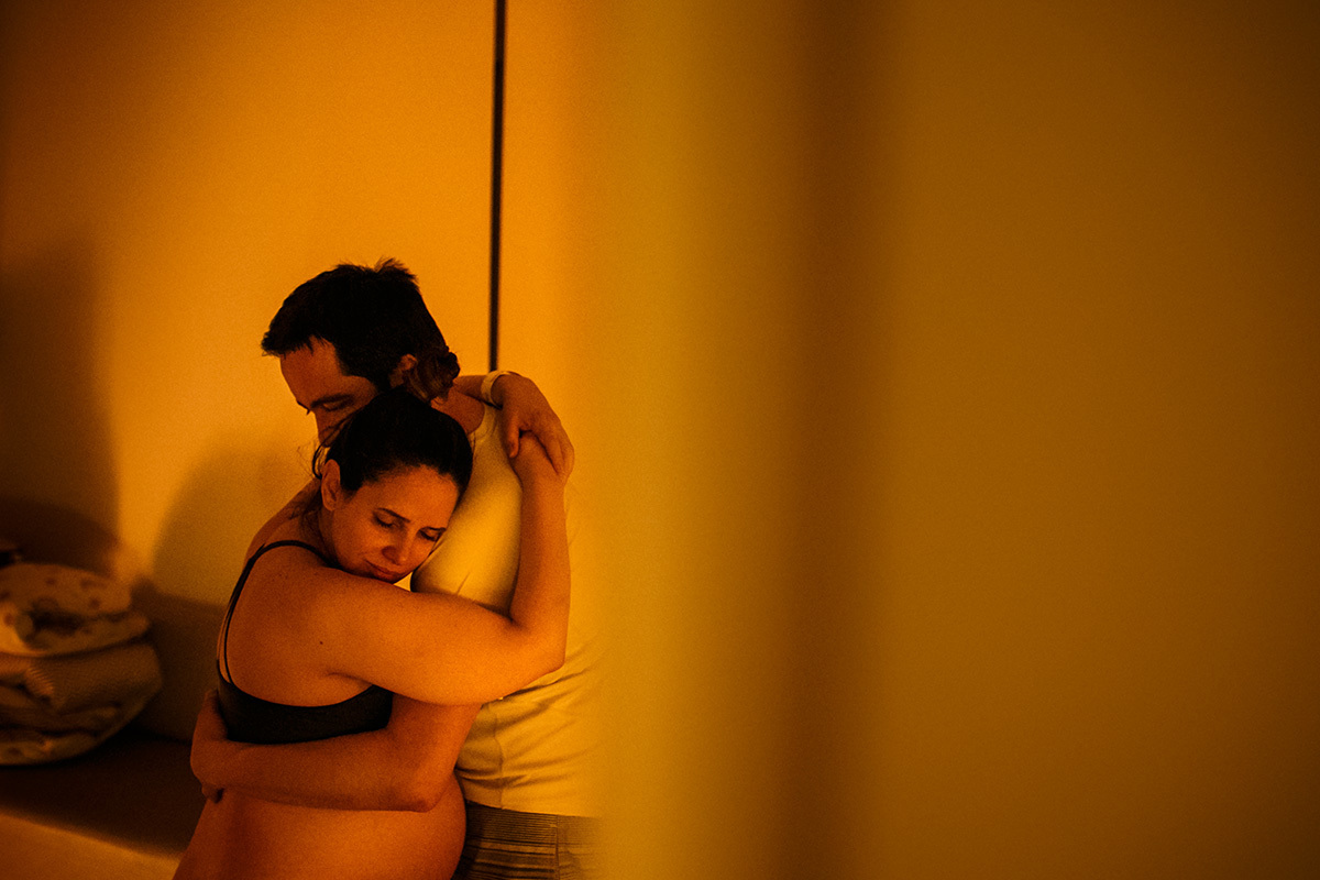 casal se abraçando durante o trabalho de parto em foto de Adriana Costa