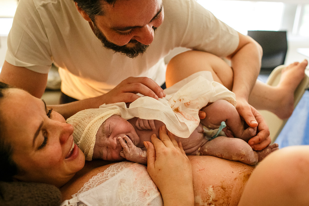 Foto de Adriana costa do casal emocionado ao receber nos braços seu bebê arco-íris