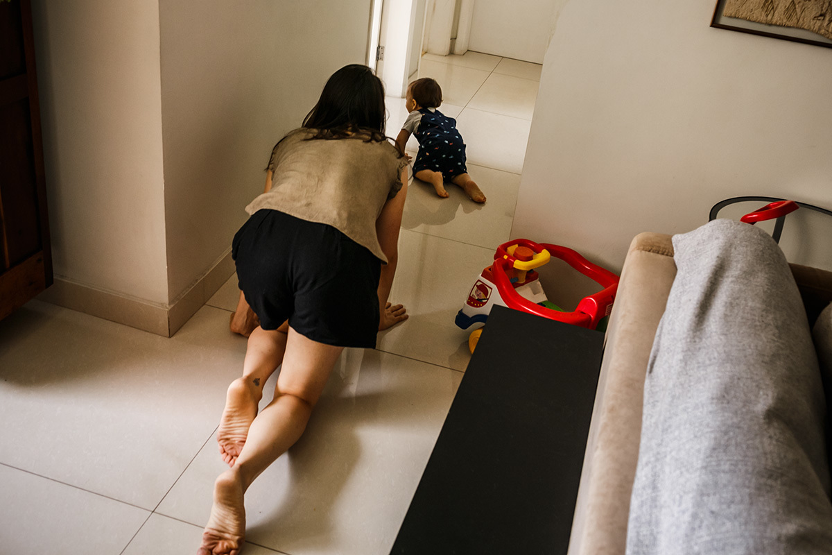 mãe brincando de pega-pega com seu bebê engatinhando junto com ele