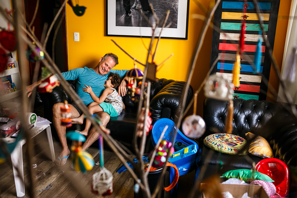 pai e filho brincam felizes no dia de montar a árvore de natal