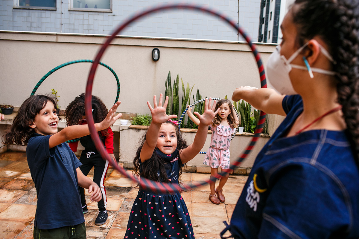 crianças brincando com bambolê em festa infantil