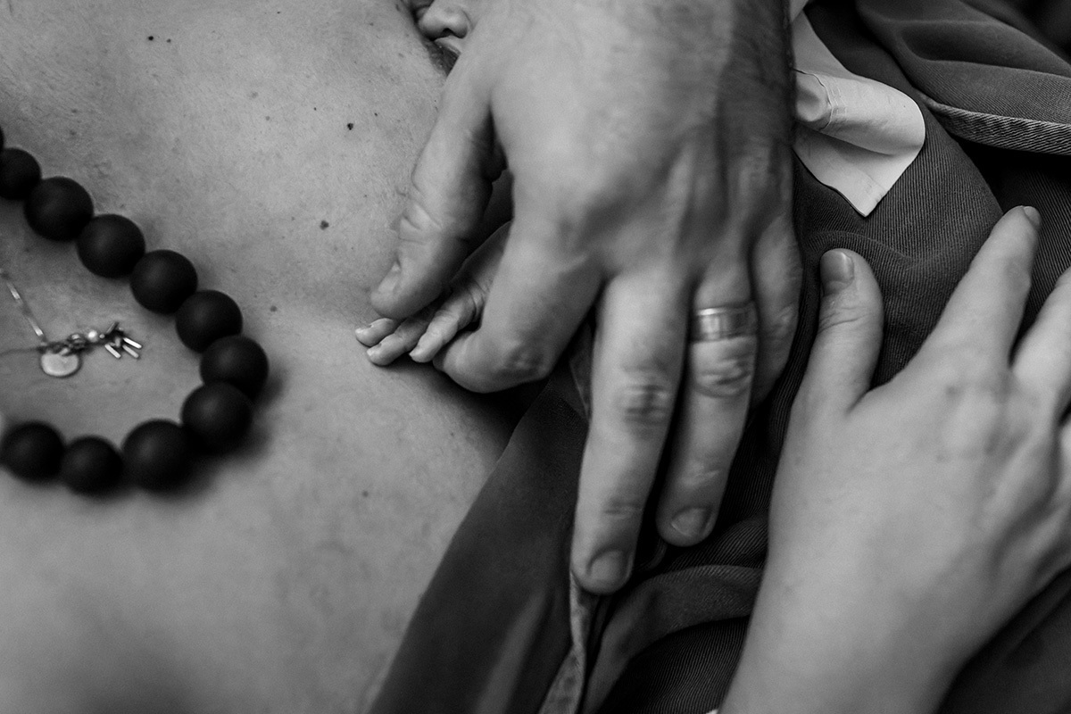 conexão pelas mãos entre pais e bebê após o nascimento