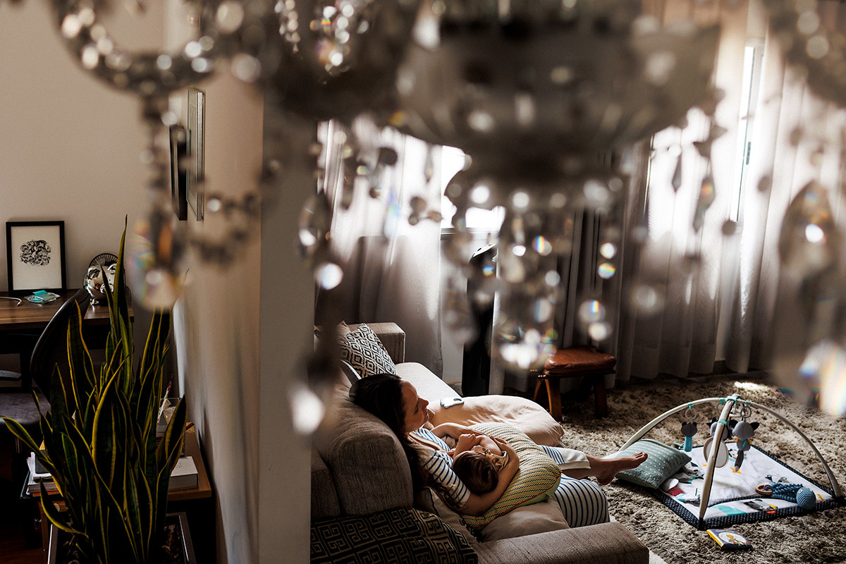 Foto de Adriana Costa da mãe com seu bebê dormindo no colo após amamentar