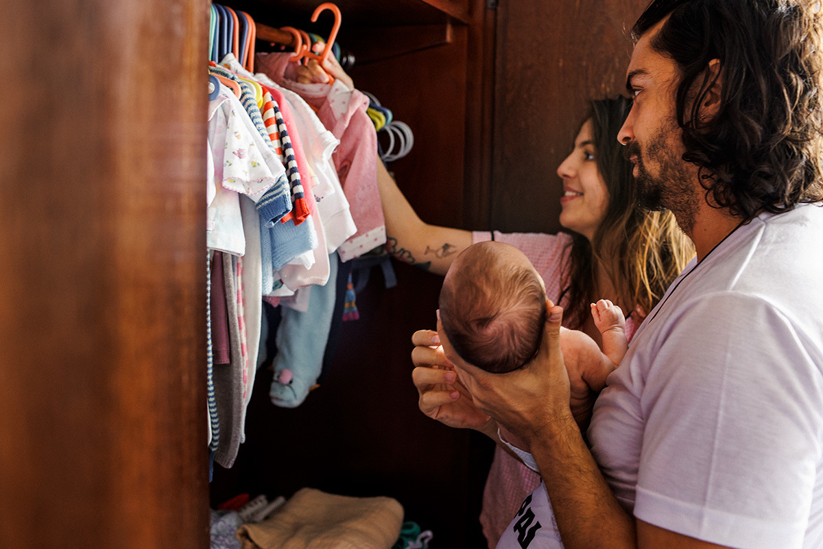 pais escolhendo juntos a roupa para colocar em sua bebê recém-nascida