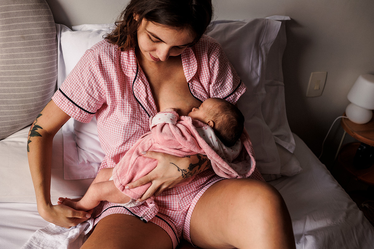 mãe amamentando se bebê pela manhã em sua casa