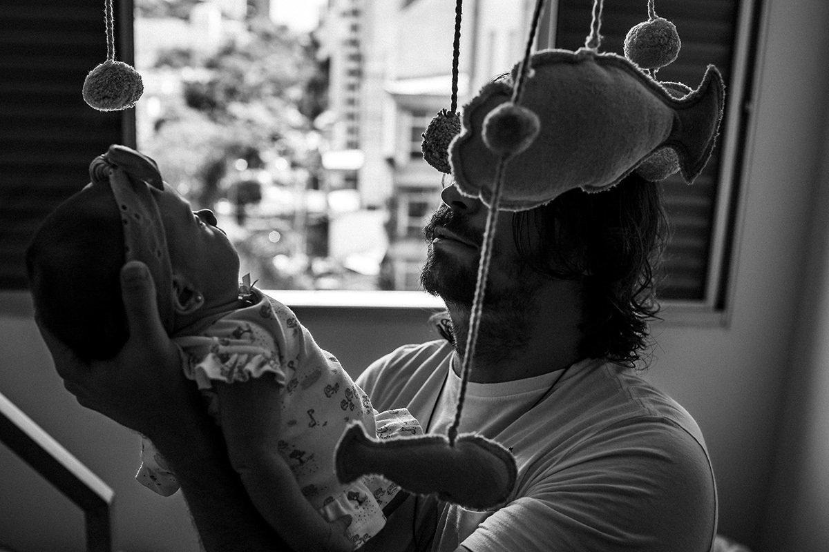 pai e sua bebê imersos no tema de praia do quarto dela