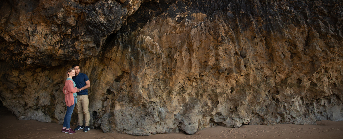 Namorados junto a rocha em tons acastanhados