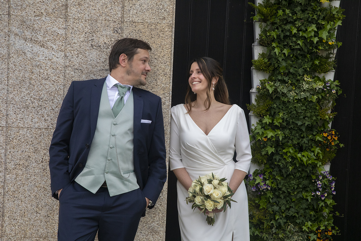 No mesmo cenário, Nuno afasta-se ligeiramente e encosta-se à parede ao lado de Rita. O olhar entre ambos reflete felicidade e sintonia.