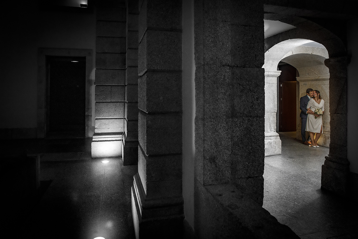 Uma composição criativa divide a imagem, à frente, a preto e branco, ao fundo, a cores. Junto a uma parede de pedra, Nuno abraça Rita de costas, enquanto ela olha para trás e o beija.