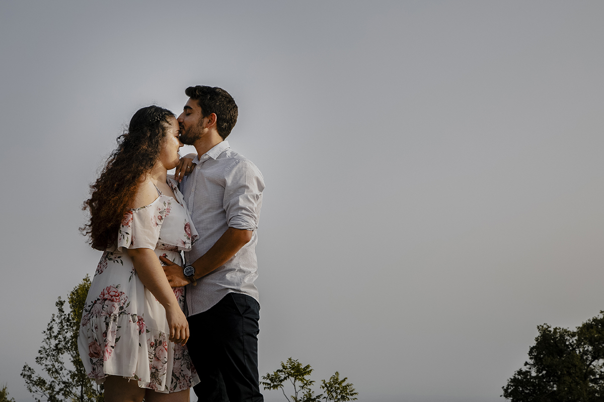 Num plano mais aproximado, Miguel beija a testa de Juliana, com a mão carinhosa pousada na barriga, num gesto de amor e proteção.