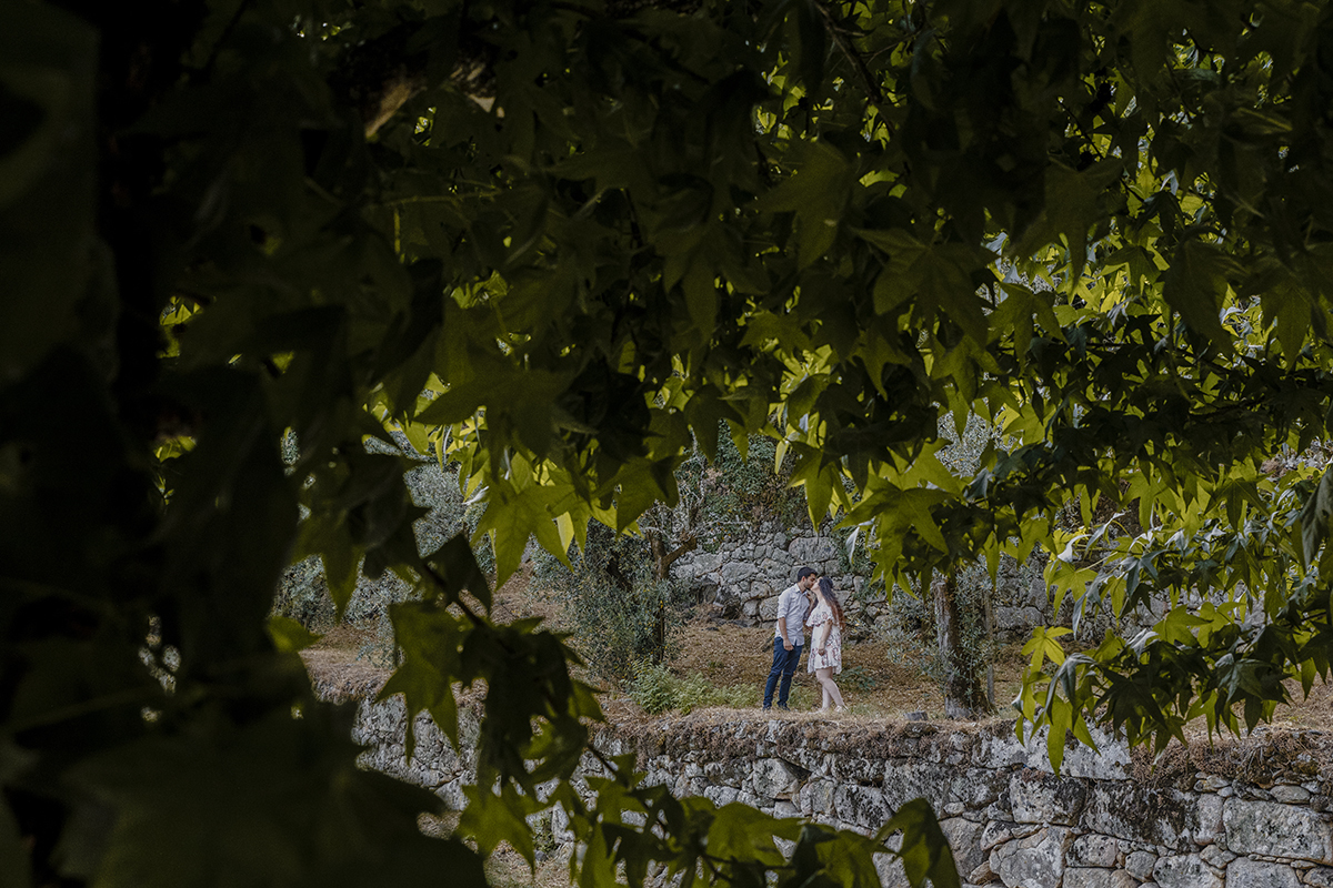 Entre folhas que quase escondem, surge um momento apaixonado: um beijo frente a frente, puro e delicado, capturado num instante mágico de conexão.