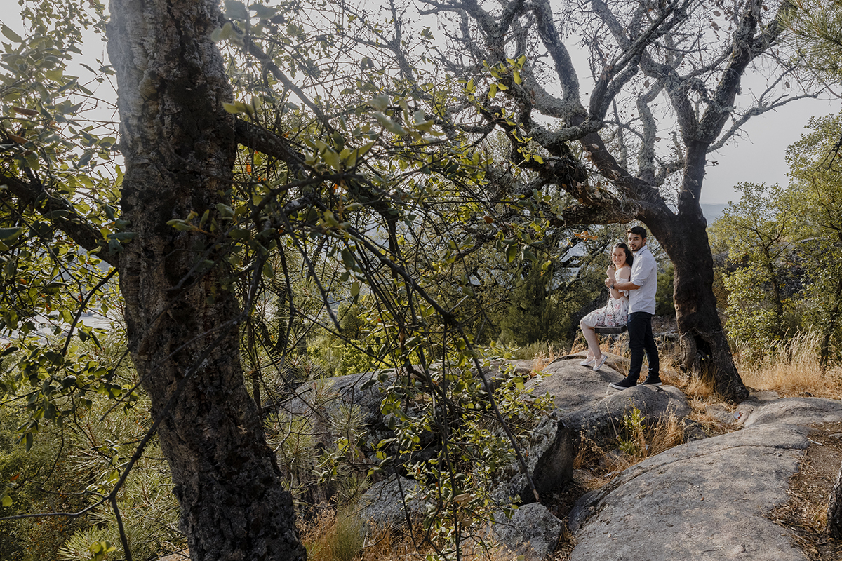 Sentados no baloiço, ela ainda segura as correntes enquanto ele a abraça por trás, e ambos olham para a câmara com sorrisos genuínos.