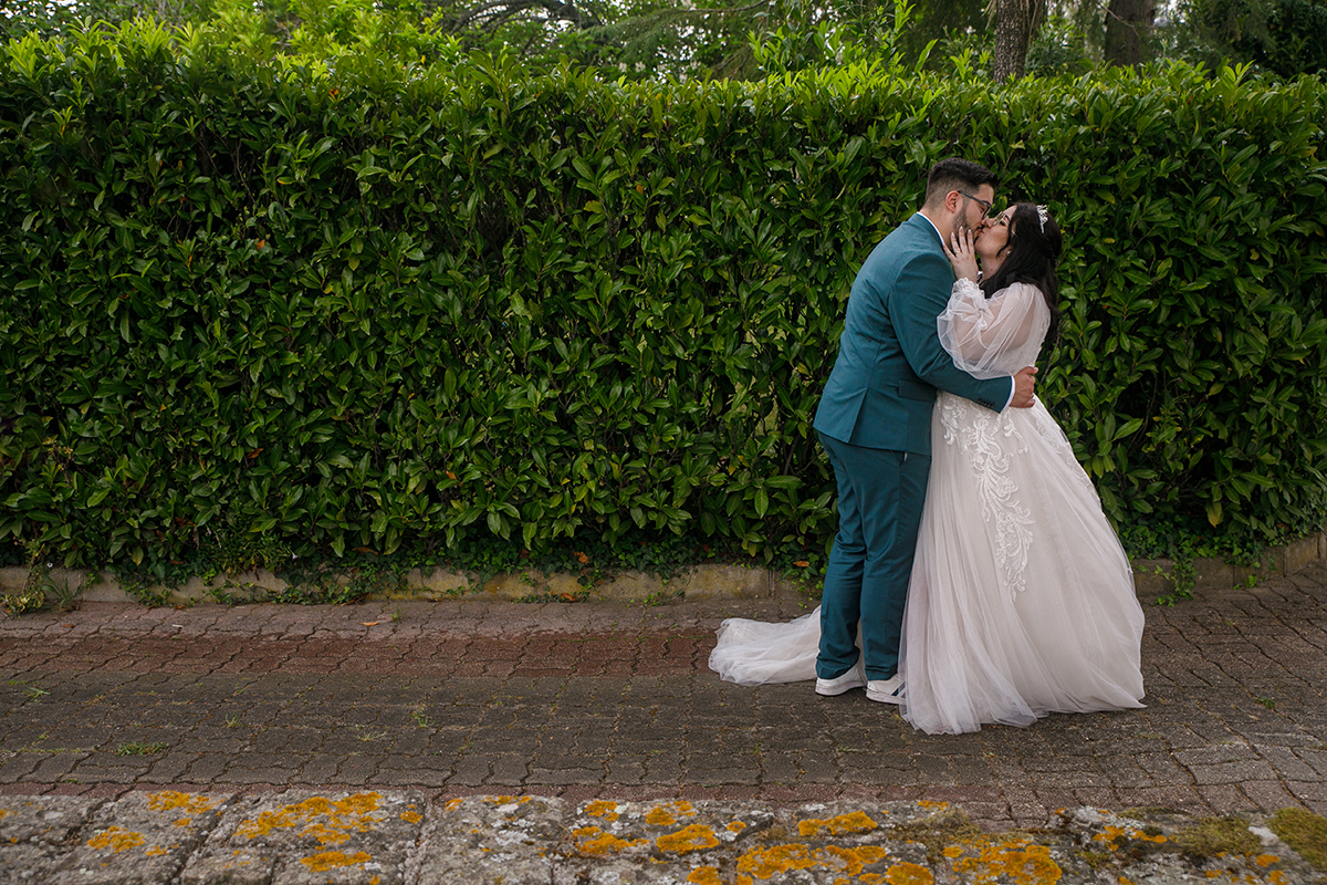 Na sequência do momento anterior, já juntos e de perfil para a câmara, entregam-se a um beijo cheio de ternura e paixão, as mãos dela nas bochechas dele enquanto ele segura a cintura dela, um instante de amor que parece suspenso no tempo.